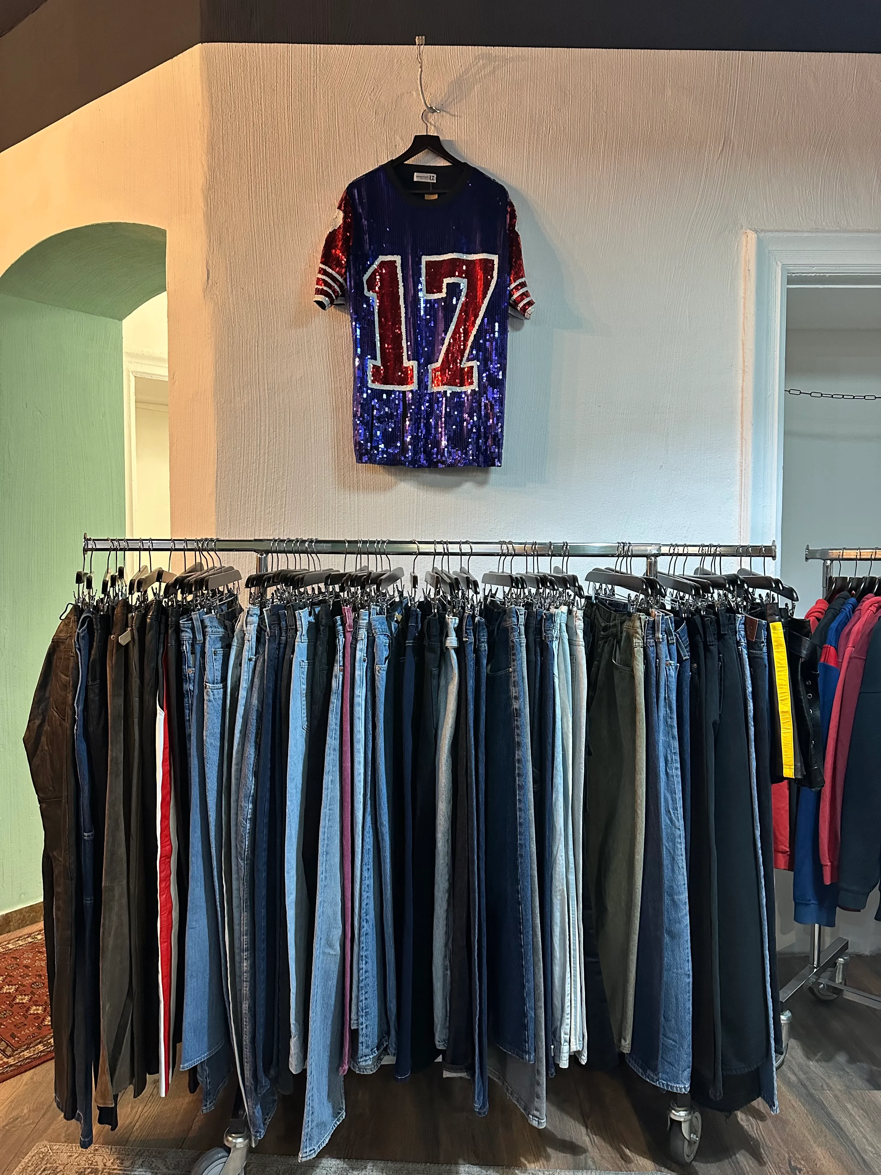 Jeans und Hosen an einer langen Kleiderstange bei Ava Vintage